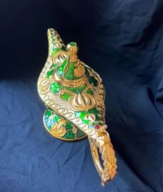 Vintage Aladdin magic genie lamp in green and gold with intricate floral engraving.