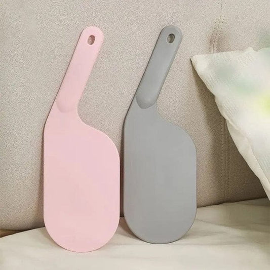 White bed sheet tucker tool tucking sheets under a heavy mattress.