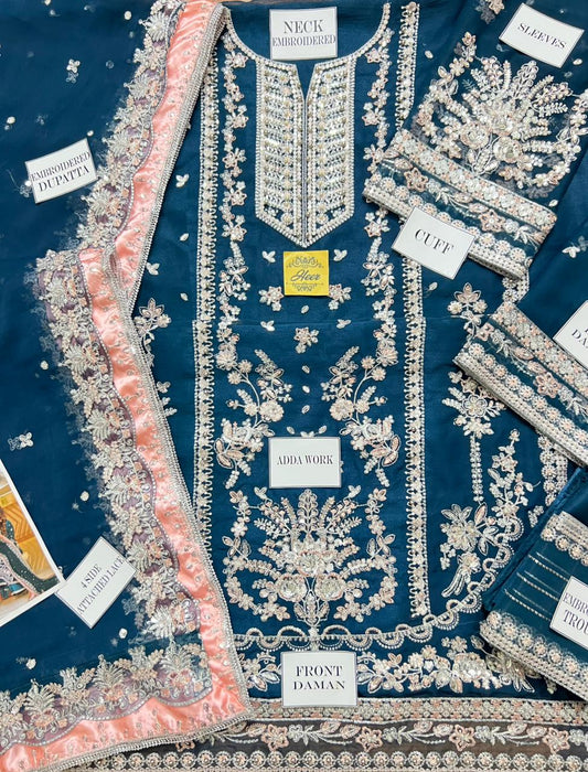 Close-up of intricate gold tilla work on a deep teal velvet festive dress.