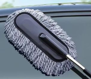 Soft microfiber car cleaning brush trapping dust on a vehicle exterior.